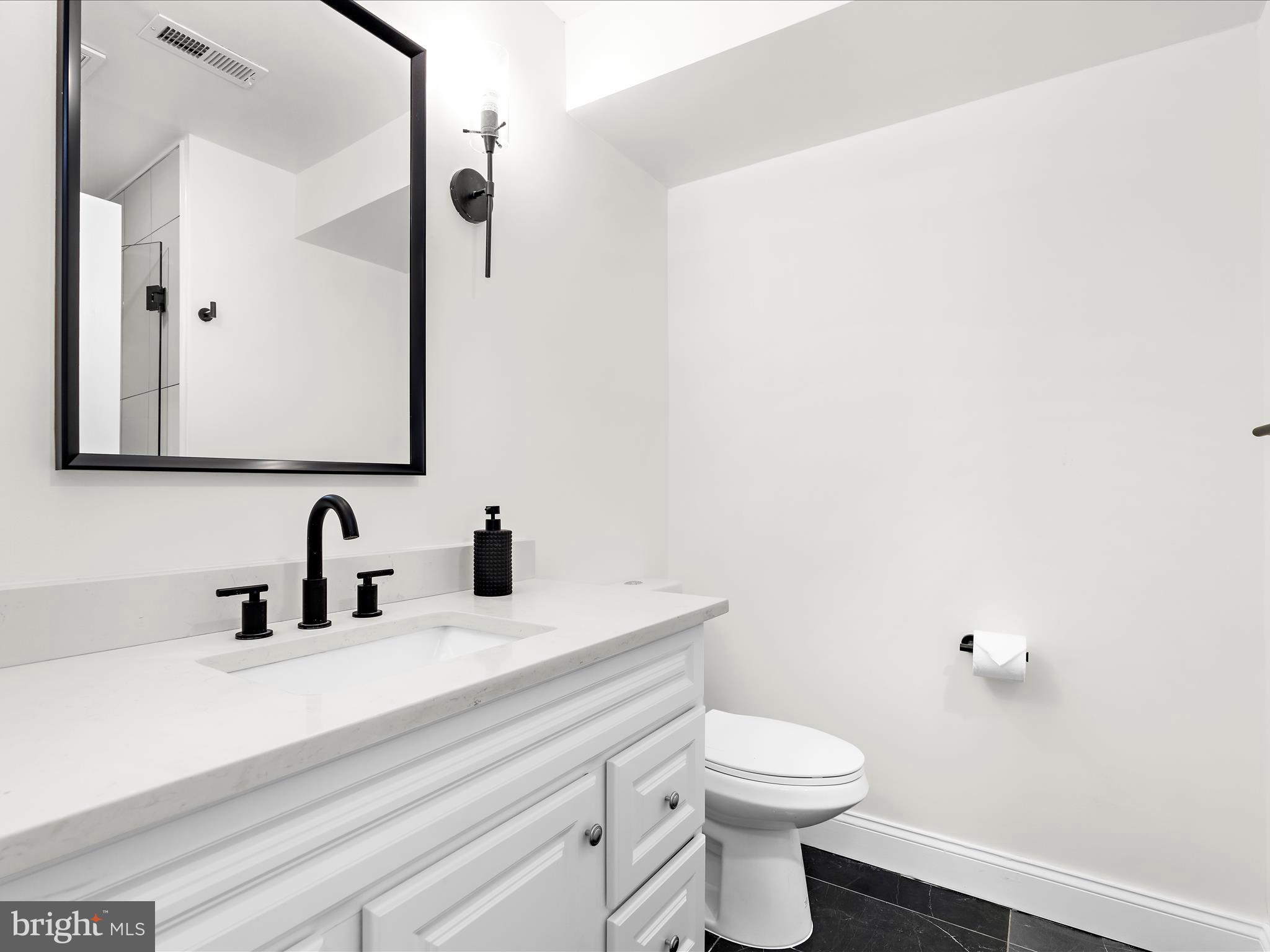 505 Mosher Street Baltimore, MD 21217 - Photo 37 of 46 a bathroom with a sink a toilet and mirror