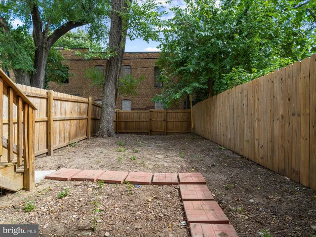 a view of a brick house with a small yard