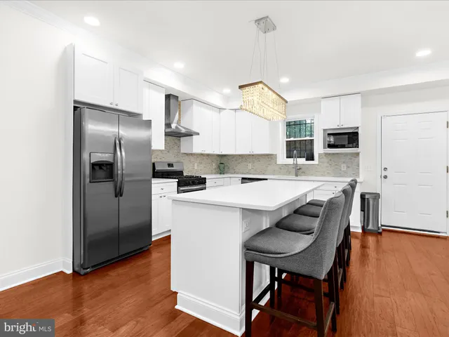 a kitchen with refrigerator cabinets and wooden floor