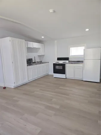 a large kitchen with cabinets wooden floor and stainless steel appliances
