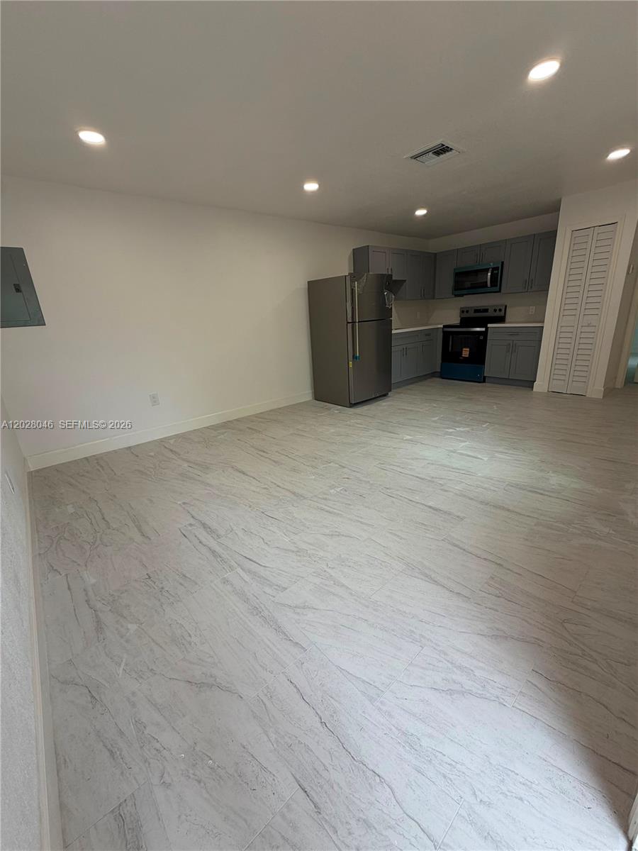 19321 Southwest 196th Street, Unit 1 Miami, FL 33187 - Photo 9 of 10 an empty room with a refrigerator and car