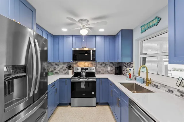 a kitchen with kitchen island granite countertop a sink stainless steel appliances and counter space