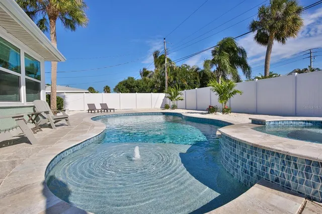 a view of a backyard with plants and palm tree