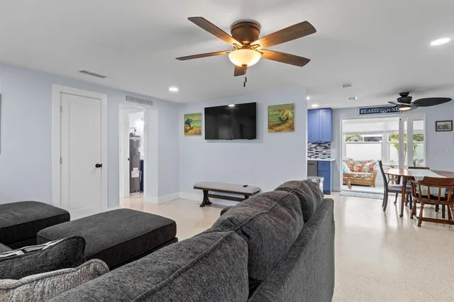 a living room with furniture ceiling fan and a flat screen tv