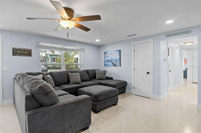 a living room with furniture and a ceiling fan