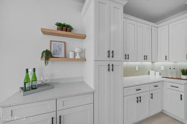 a dining room with stainless steel appliances kitchen island granite countertop a table chairs and a refrigerator