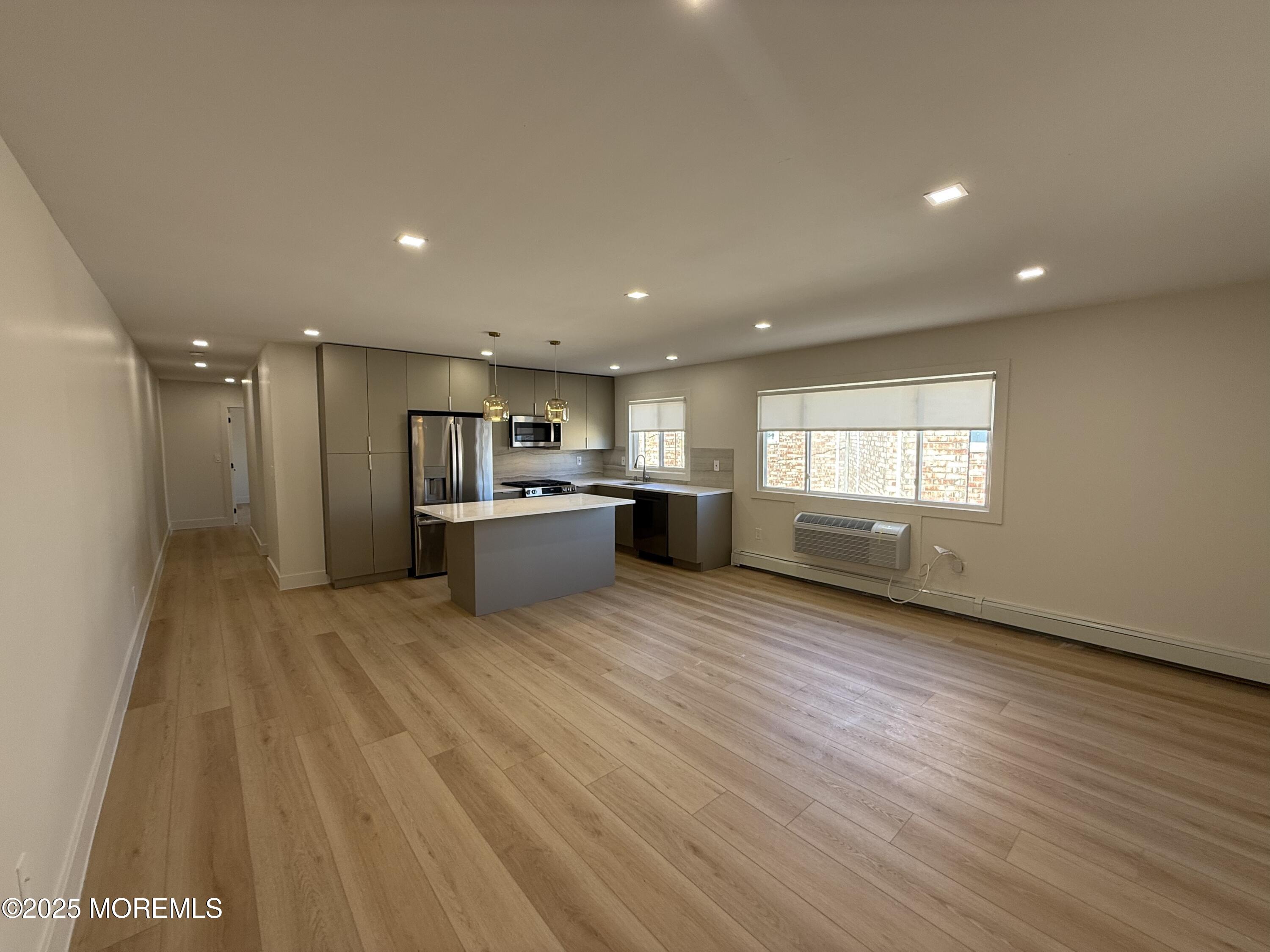 a view of a kitchen with a sink and a refrigerator