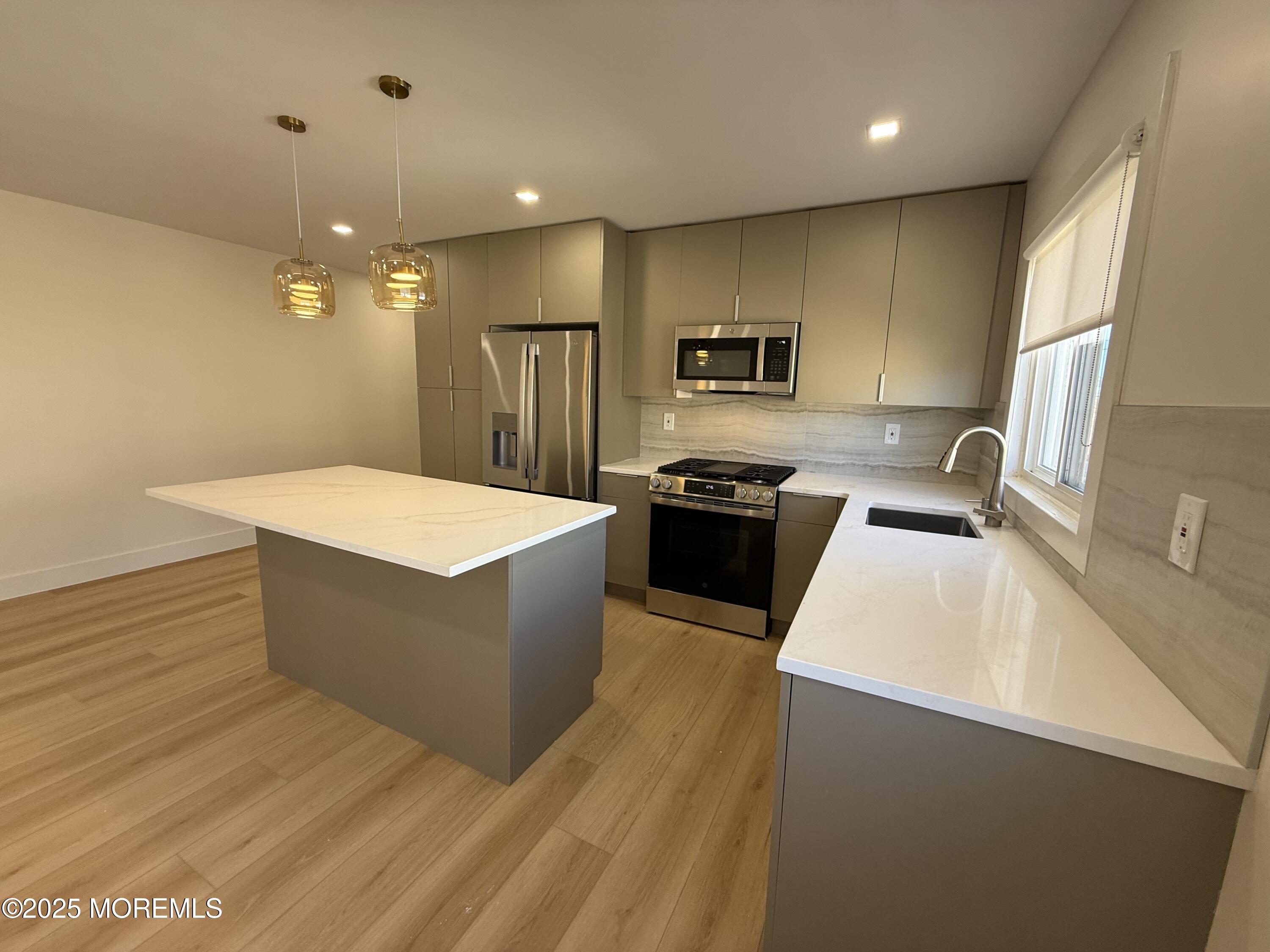 1 North Ocean Avenue, Unit 18 Belmar, NJ 07719 - Photo 3 of 10 a large kitchen with stainless steel appliances a large counter top a stove a sink dishwasher and a refrigerator