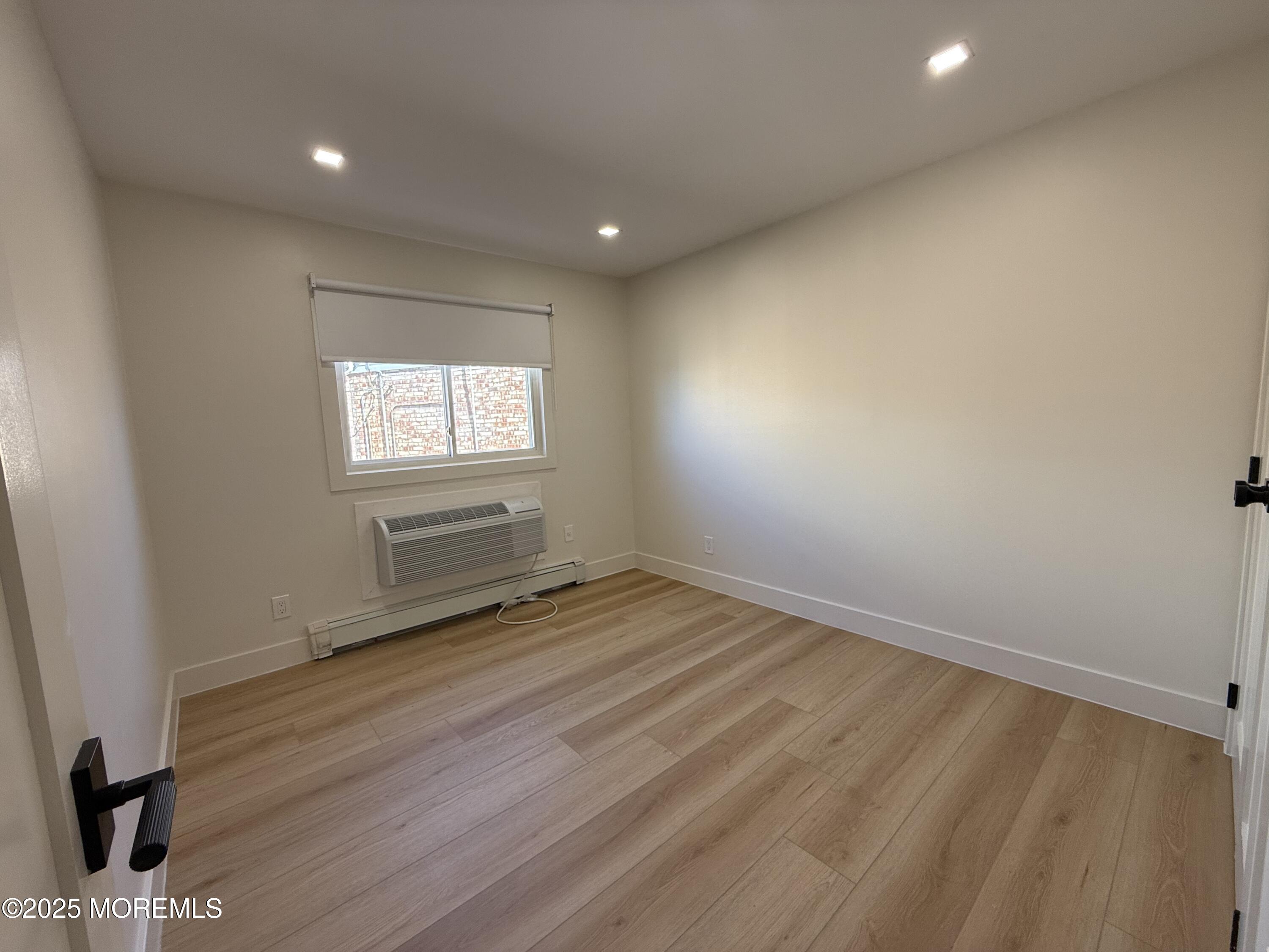 1 North Ocean Avenue, Unit 18 Belmar, NJ 07719 - Photo 6 of 10 an empty room with wooden floor and windows