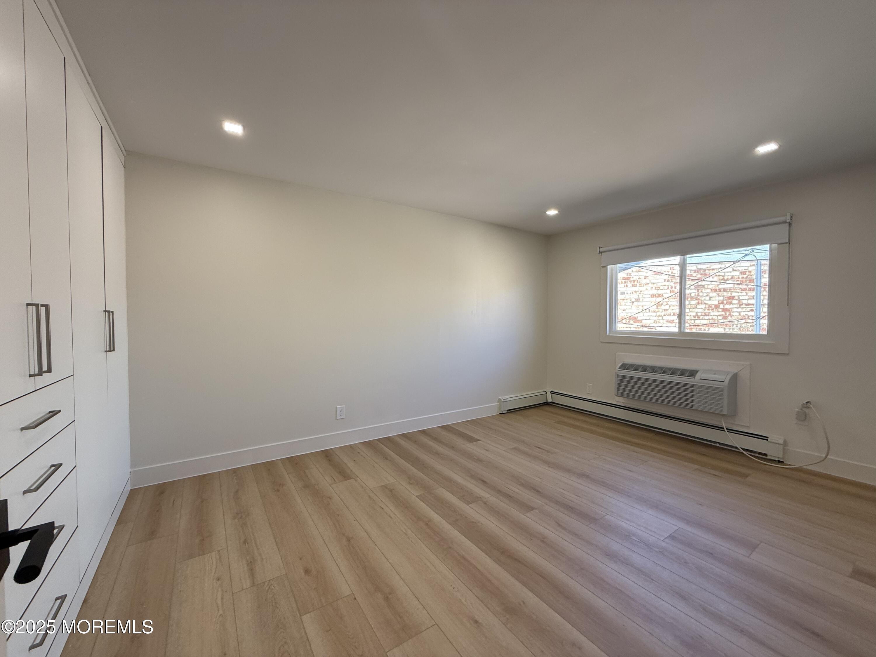 1 North Ocean Avenue, Unit 18 Belmar, NJ 07719 - Photo 8 of 10 an empty room with wooden floor and windows