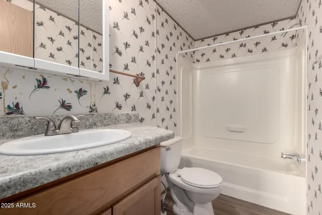 a bathroom with a granite countertop sink toilet and shower