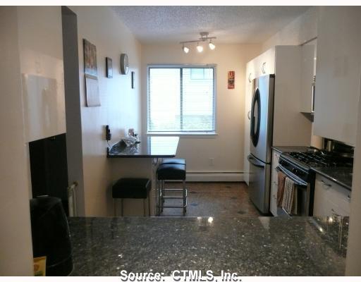 1 Talcott Forest Road, Unit 1P Farmington, CT 06032 - Photo 1 of 1 a kitchen with stainless steel appliances kitchen island granite countertop a refrigerator stove and sink