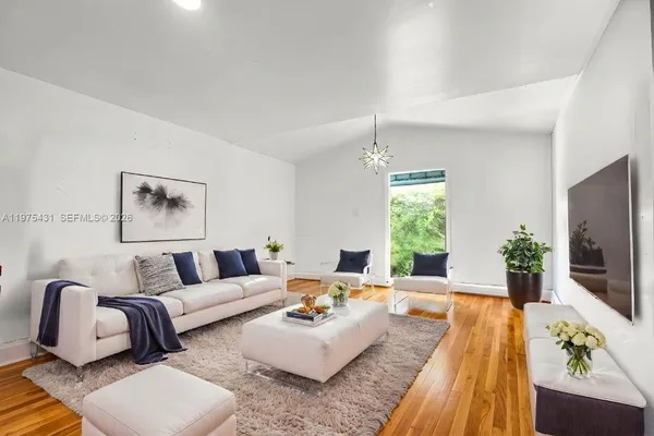 a living room with furniture flat screen tv and window