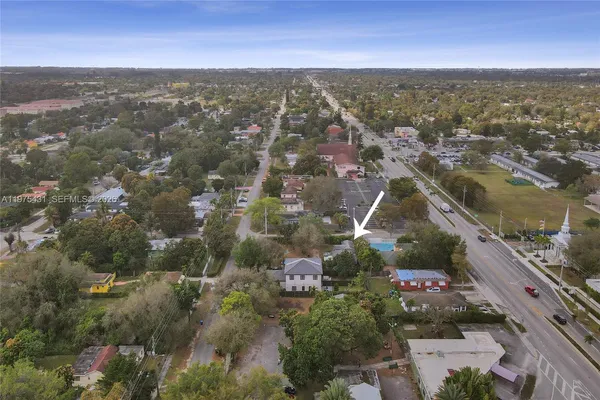 an aerial view of residential houses with outdoor space and trees