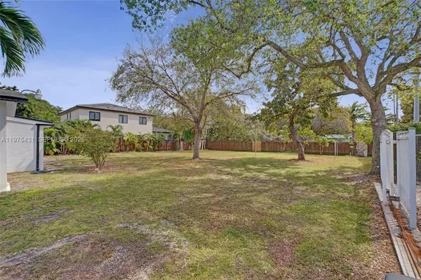 a view of a yard with a house in the background