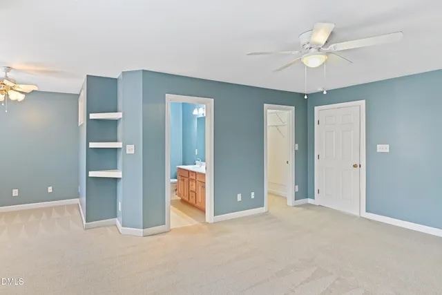 a view of an empty room with a ceiling fan