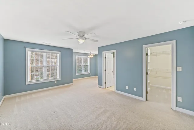 an empty room with windows and closet