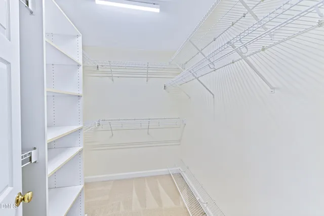 a view of walk in closet with empty racks