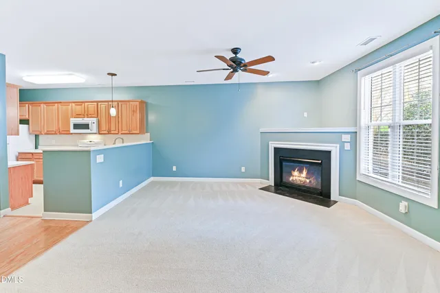 a view of kitchen with fireplace ceiling fan and window