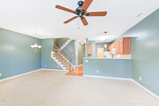 a view of a livingroom with wooden floor and a ceiling fan