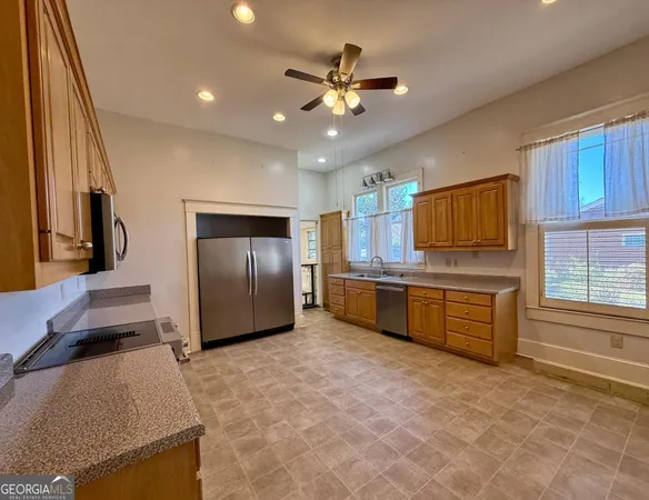 a kitchen with stainless steel appliances granite countertop a stove a sink and a refrigerator