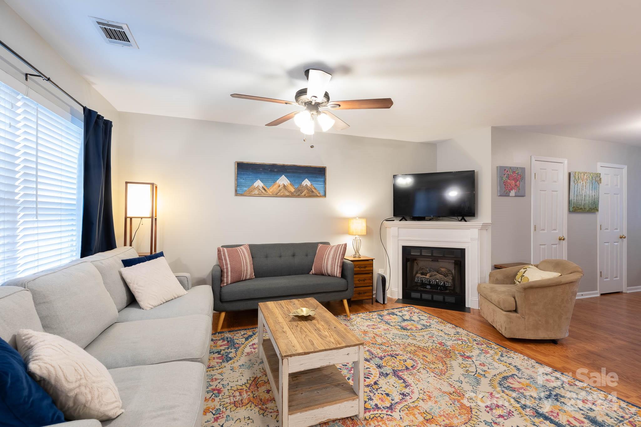 1681 Alpine Ridge Place Rock Hill, SC 29732 - Photo 3 of 20 a living room with furniture a flat screen tv and a fireplace