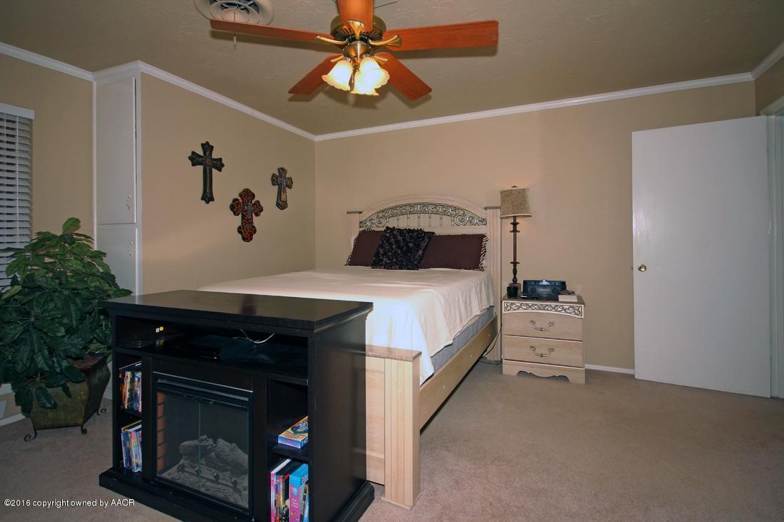 4213 Farmers Avenue Amarillo, TX 79110 - Photo 11 of 24 a bedroom with a bed and a fireplace