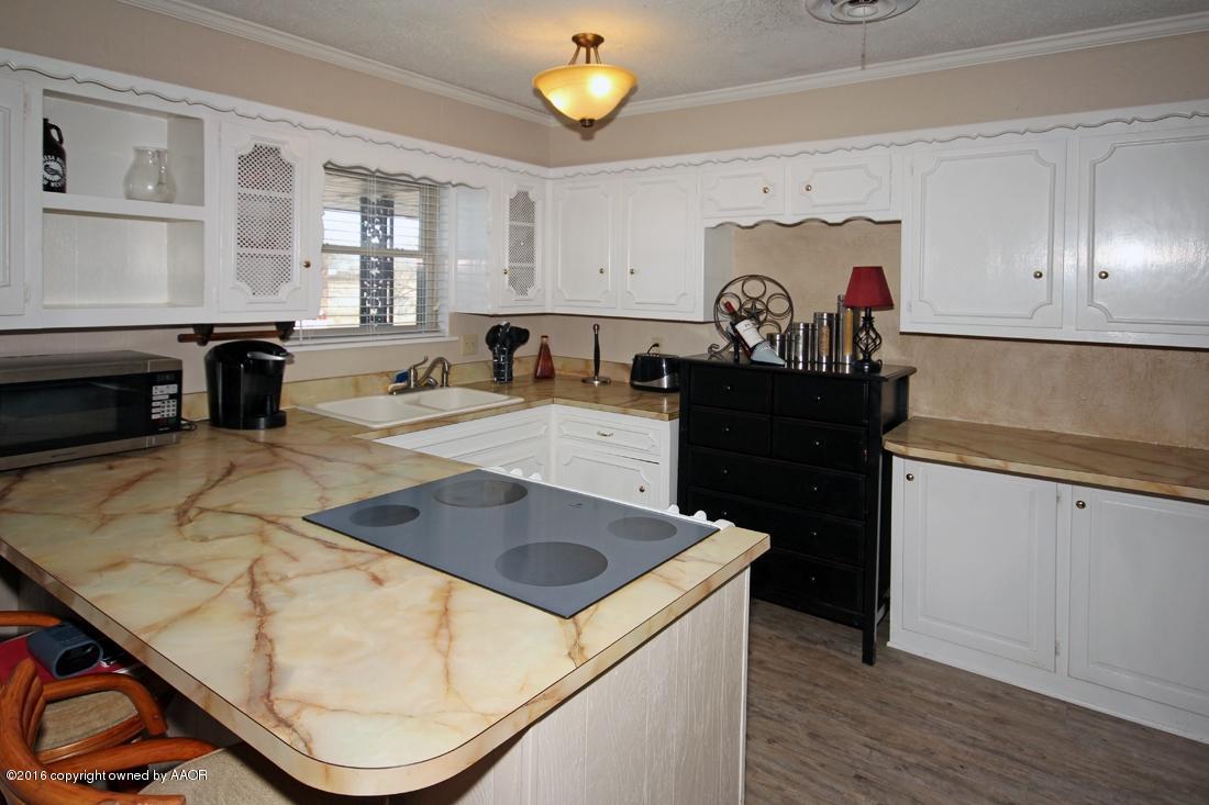 4213 Farmers Avenue Amarillo, TX 79110 - Photo 7 of 24 a kitchen with a sink a stove and cabinets