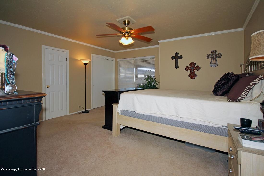 4213 Farmers Avenue Amarillo, TX 79110 - Photo 10 of 24 a bedroom with a bed and a chandelier