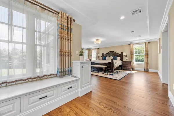 a living room with furniture hard wood floor and a floor to ceiling window