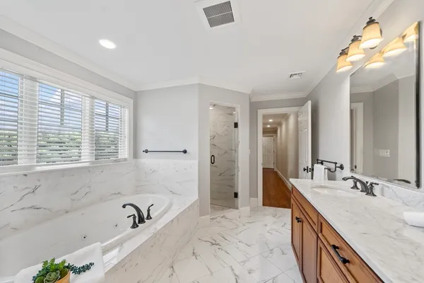 a bathroom with a granite countertop tub sink and mirror