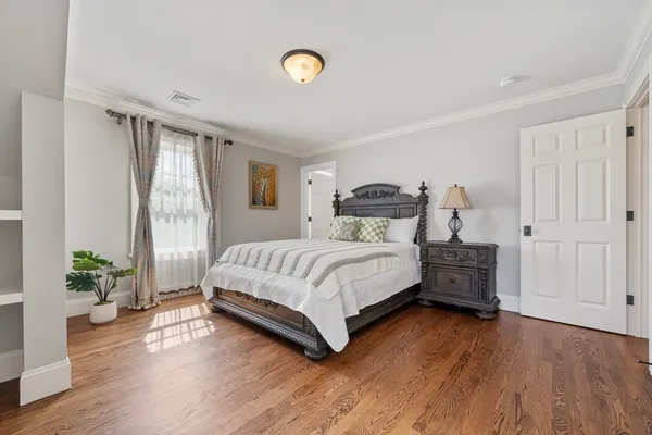 a bedroom with a bed table and a window