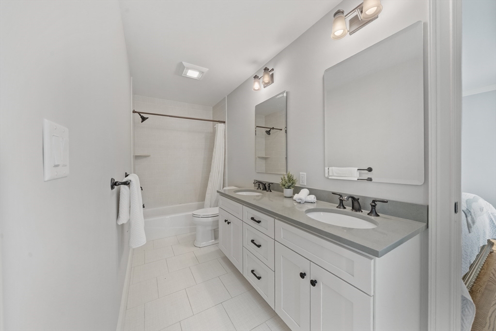 18 Victory Garden Way Lexington, MA 02420 - Photo 29 of 42 a bathroom with a double vanity sink mirror double and shower