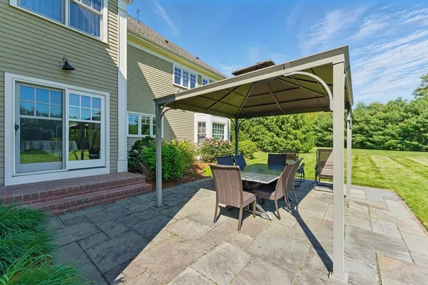 a view of a chair and table in backyard of the house