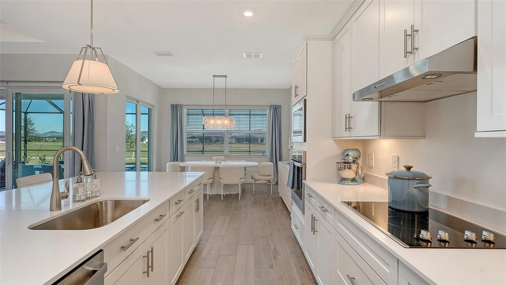 17160 Albatross Road Venice, FL 34293 - Photo 14 of 91 a large kitchen with kitchen island a large counter space a sink stainless steel appliances and cabinets