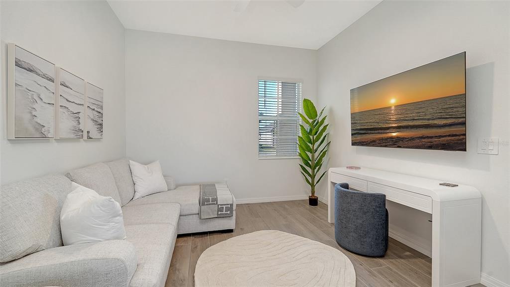 17160 Albatross Road Venice, FL 34293 - Photo 18 of 91 a living room with furniture a flat screen tv and a potted plant
