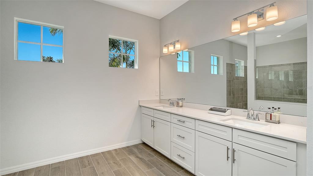 17160 Albatross Road Venice, FL 34293 - Photo 22 of 91 a bathroom with a double vanity sink and a mirror