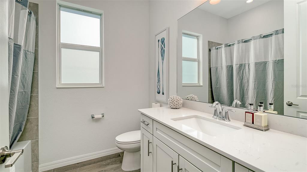 17160 Albatross Road Venice, FL 34293 - Photo 27 of 91 a bathroom with a granite countertop sink toilet and mirror