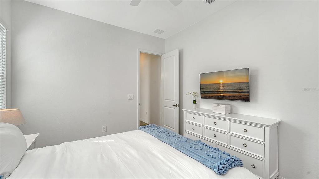 17160 Albatross Road Venice, FL 34293 - Photo 30 of 91 a bedroom with a bed and a flat screen tv