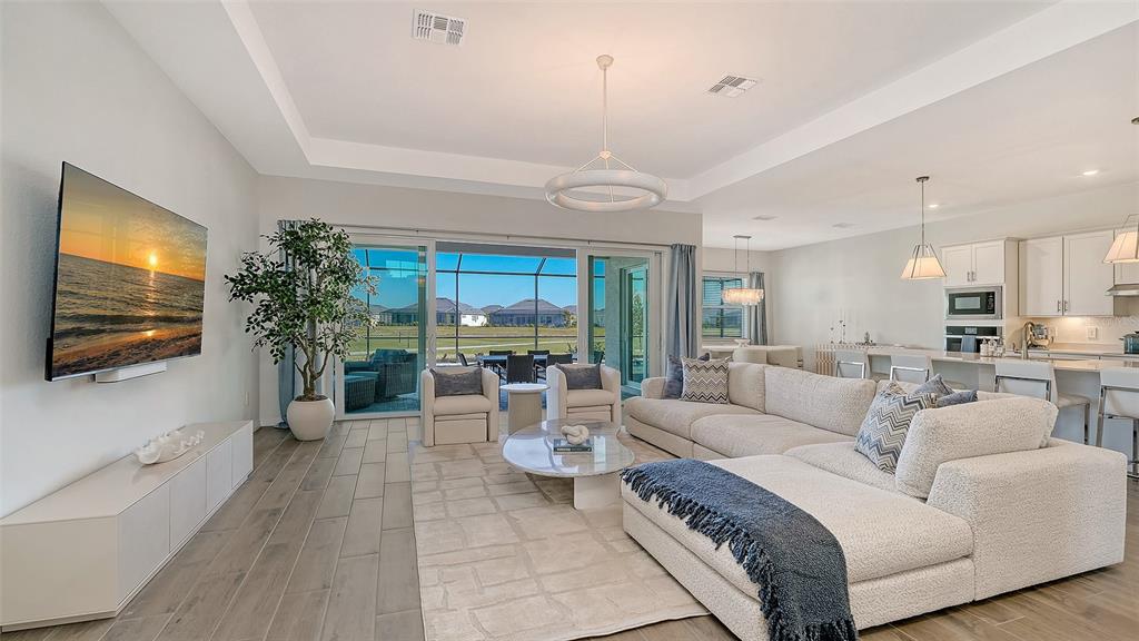 17160 Albatross Road Venice, FL 34293 - Photo 6 of 91 a living room with furniture a flat screen tv and a large window