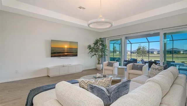 a kitchen with stainless steel appliances granite countertop a refrigerator a sink a stove a dining table and chairs