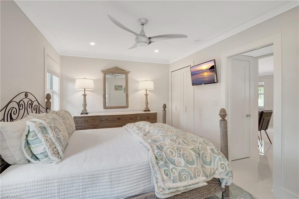 603 12th Avenue South Naples, FL 34102 - Photo 12 of 47 a bedroom with a large bed and a chandelier