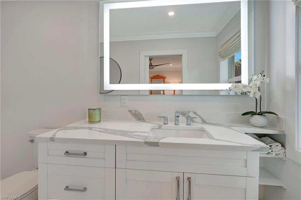 603 12th Avenue South Naples, FL 34102 - Photo 14 of 47 a bathroom with a sink and a mirror
