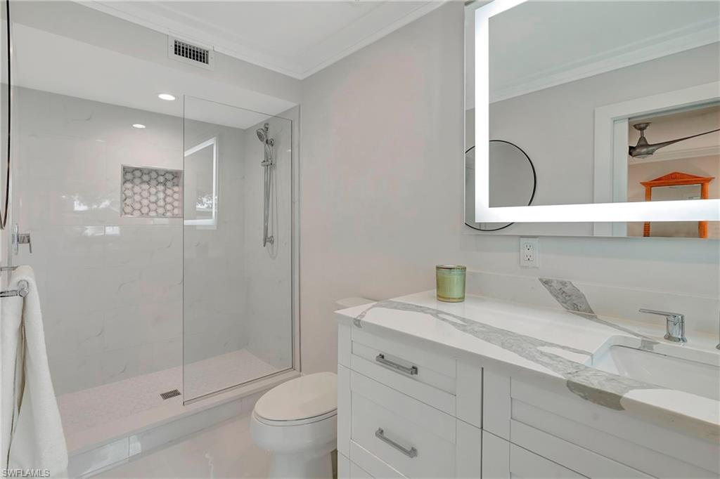 603 12th Avenue South Naples, FL 34102 - Photo 15 of 47 a bathroom with a granite countertop sink a toilet and shower