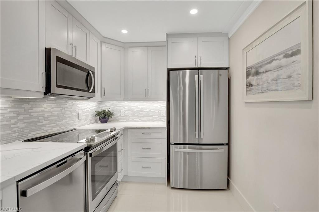 603 12th Avenue South Naples, FL 34102 - Photo 4 of 47 a kitchen with stainless steel appliances granite countertop a refrigerator and a stove top oven