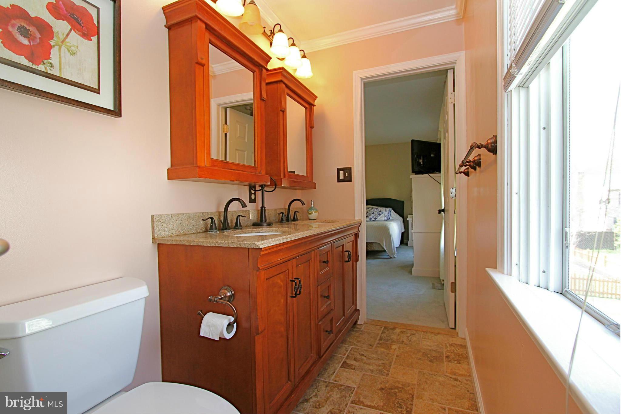 9338 Ramblebrook Road Baltimore, MD 21236 - Photo 15 of 25 a en suite bathroom with a granite countertop sink and a mirror