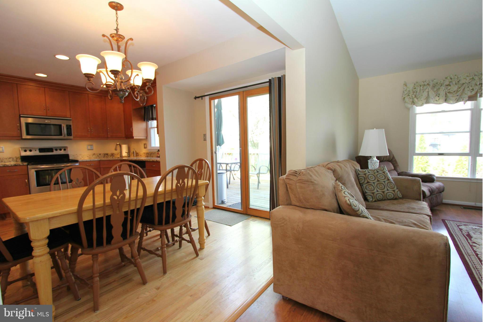 9338 Ramblebrook Road Baltimore, MD 21236 - Photo 8 of 25 a living room with furniture a dining table and a chandelier
