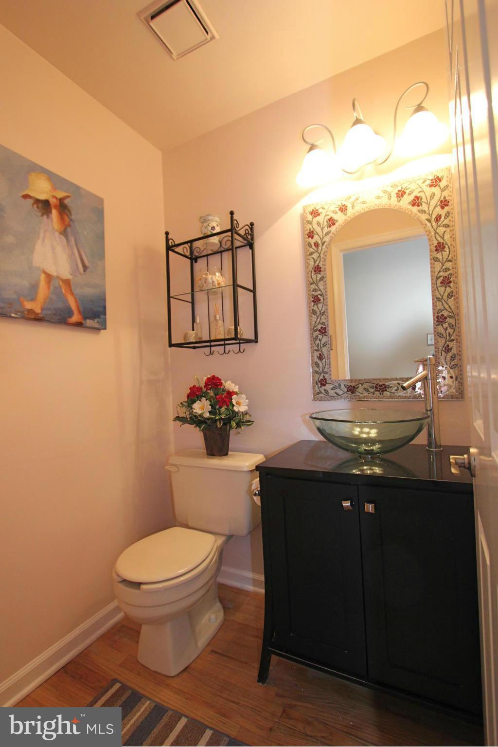 9338 Ramblebrook Road Baltimore, MD 21236 - Photo 9 of 25 a bathroom with a toilet a sink and mirror