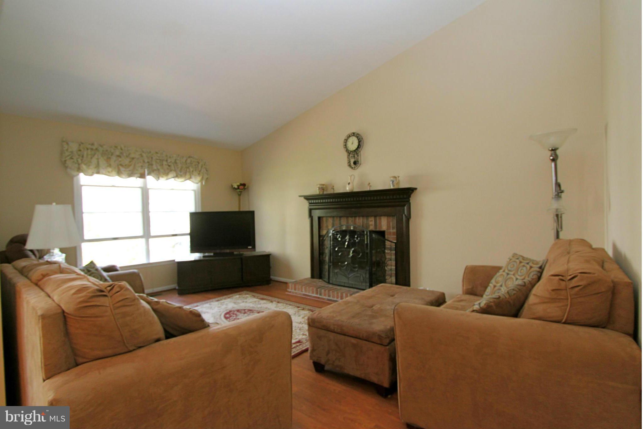 9338 Ramblebrook Road Baltimore, MD 21236 - Photo 10 of 25 a living room with a couch and a fireplace