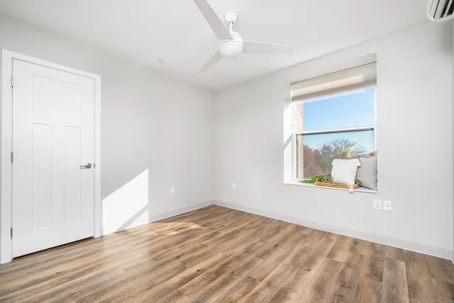 an empty room with wooden floor and windows